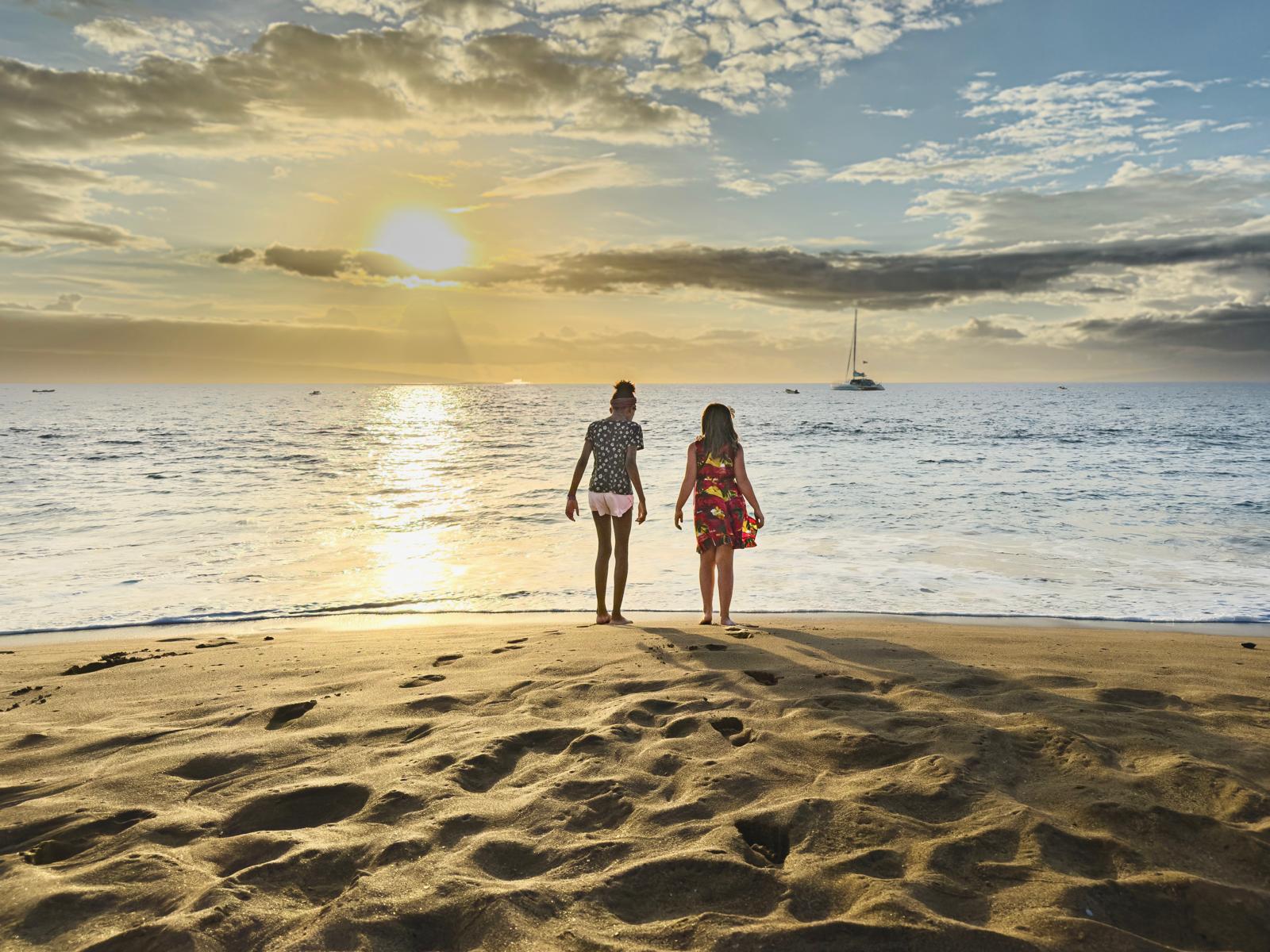 Two kids on a Hawaii beach at sunset